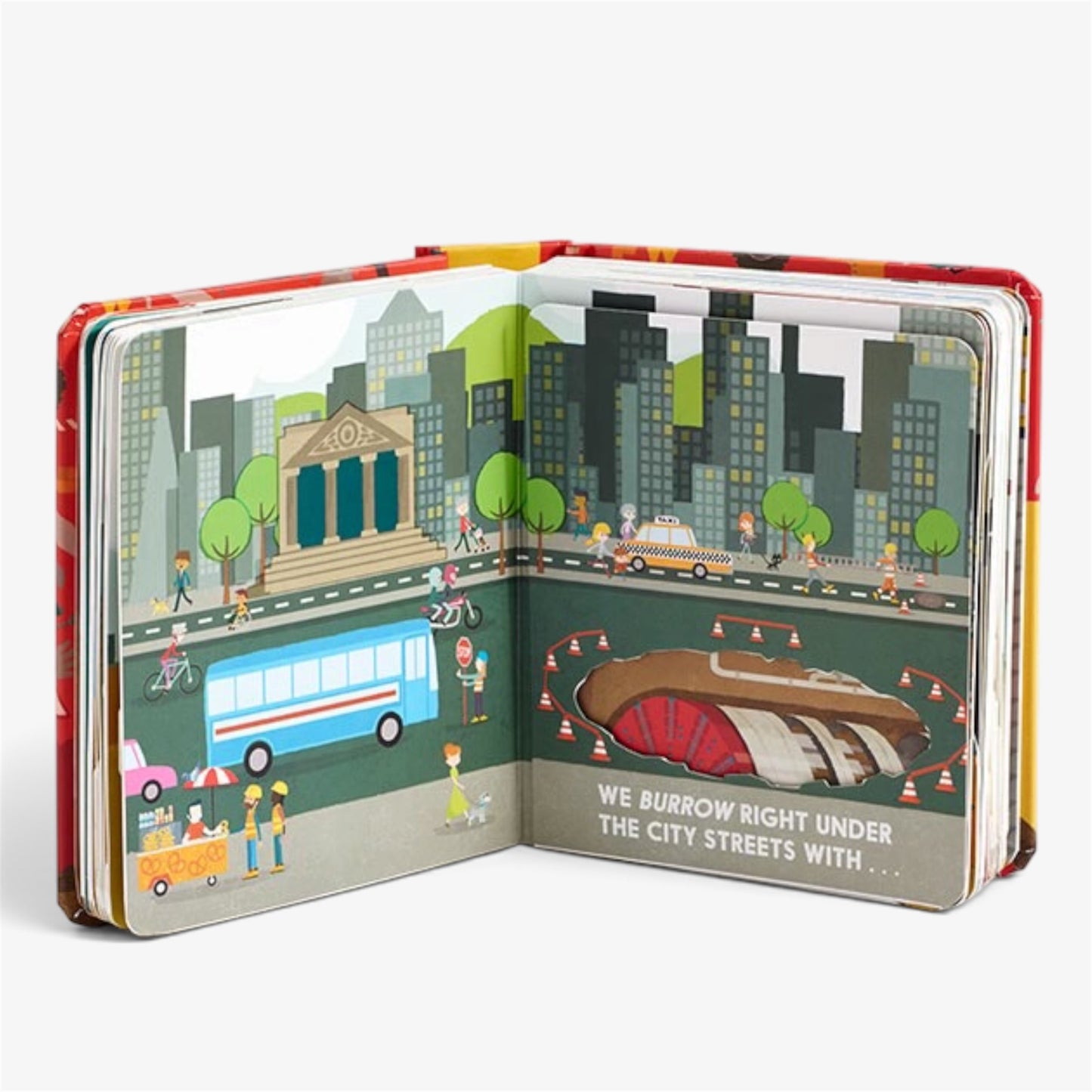 An open children's pop-up book showing a city street scene with buildings, a bus, pedestrians, and a tunnel entrance. The right page has the text, 'WE BURROW RIGHT UNDER THE CITY STREETS WITH.