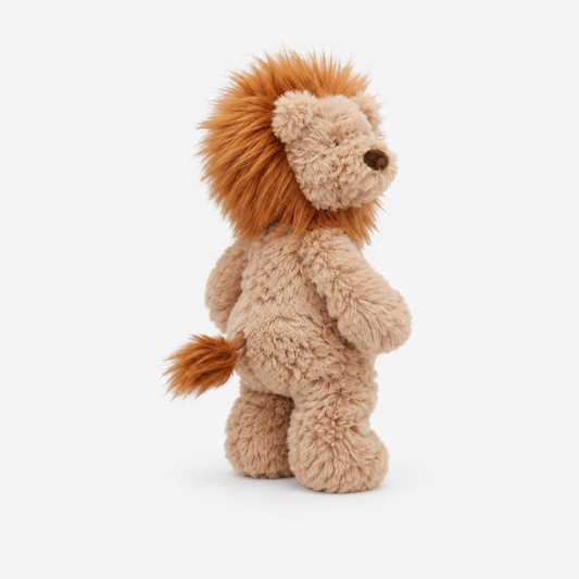 A plush lion toy standing upright, shown from the back on a clean white background. The toy has a light tan body with a fluffy orange-brown mane and tail, and a small dark embroidered nose.