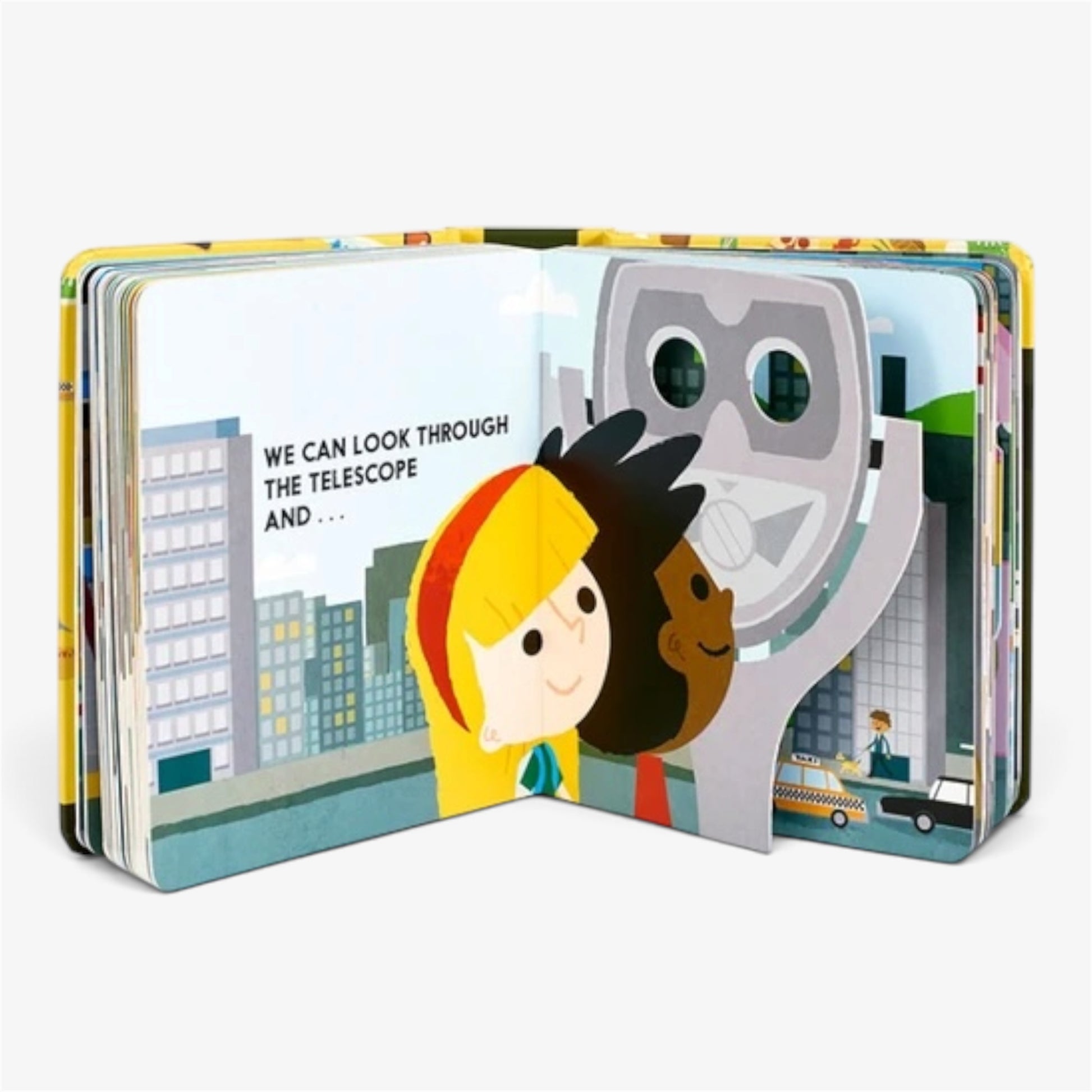 An open children's board book with colorful illustrated pages showing two children and a large telescope, photographed on a light gray background.