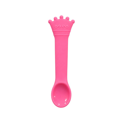 Pink crown-shaped silicone baby spoon on white background.