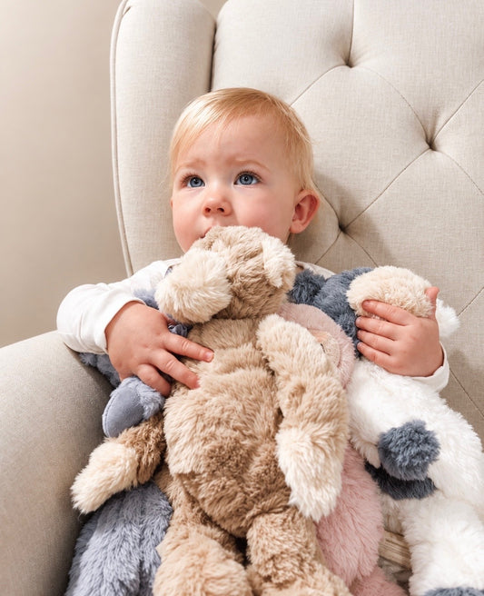 Child seated in a cream chair holding Felix and other plush toys