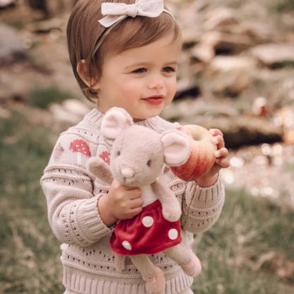 Child holding the Magical Mouse plush doll outdoors