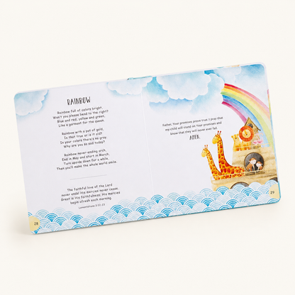 An open children's book spread showing a colorful poem titled 'Rainbow' with illustrations of clouds, rainbows, a giraffe, and a sunset over water on a cream background.
