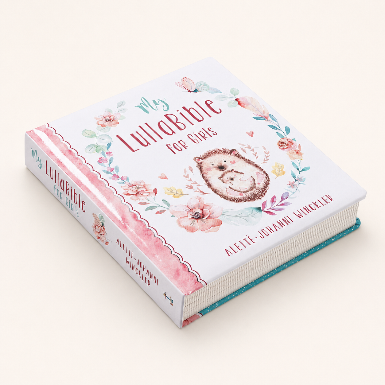 Angled view of My LullaBible for Girls padded board book showing the floral cover, pink spine, and thick pages