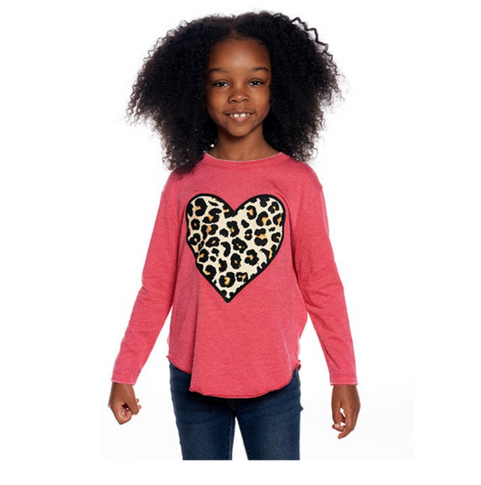 A girl wearing a long sleeve pink t-shirt with a leopard print heart design on the front and blue jeans.