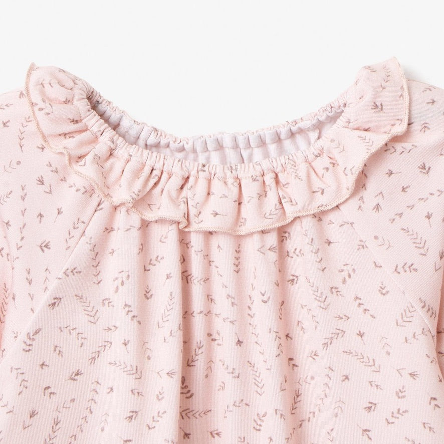 Close-up of blush wildflower baby top with stretchy ruffle collar and floral print on white backgound