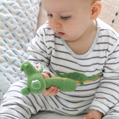 Close-up of hand-crocheted crocodile appliqué on baby romper