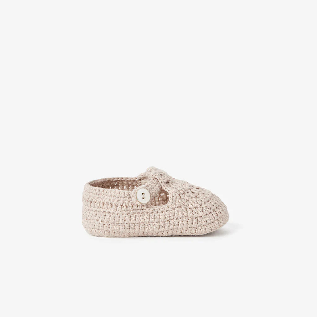 Side view of a doeskin beige cotton knit T-strap baby bootie on white background