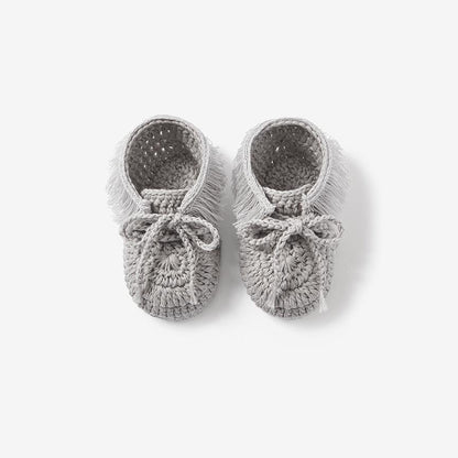 Top view of gray hand-crocheted moccasin baby booties on white background