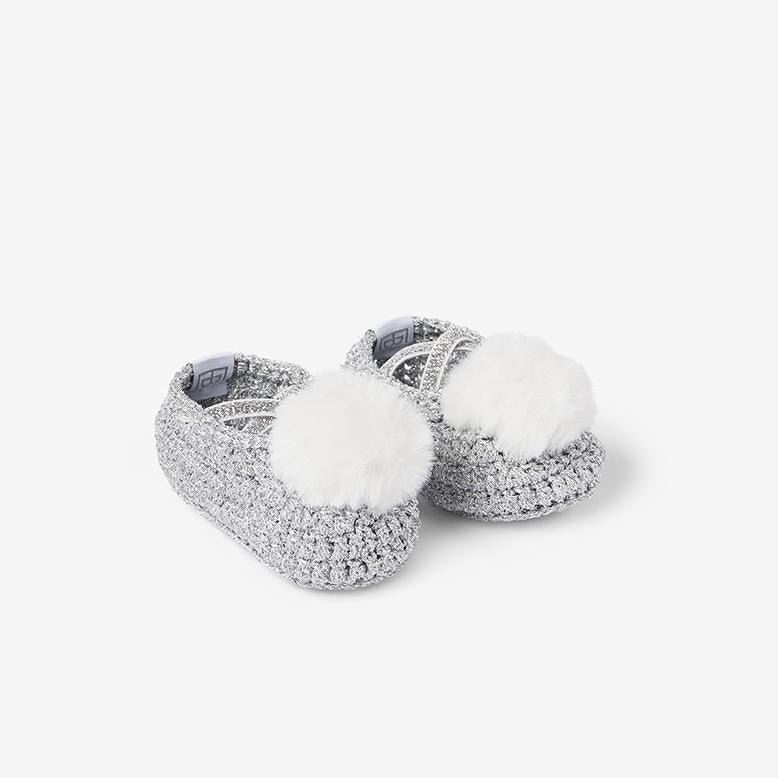 Front view of silver metallic cotton baby booties with white pom-poms on white background