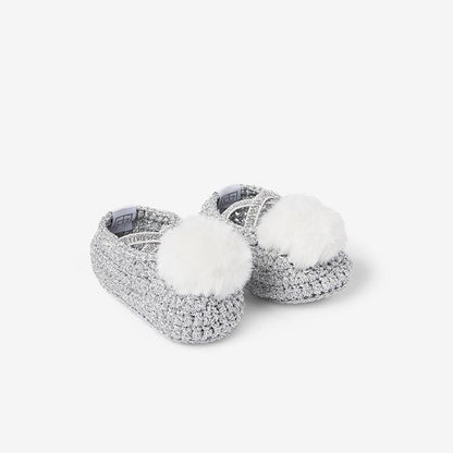 Front view of silver metallic cotton baby booties with white pom-poms on white background
