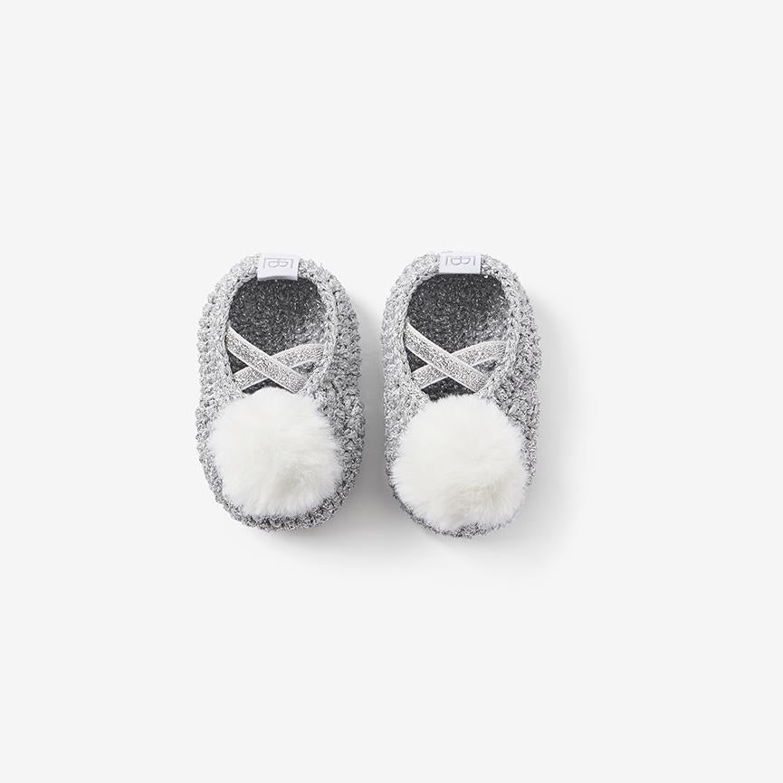 Top view of silver-gray knit baby booties showing the openings and pom-poms on white background