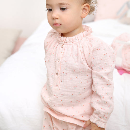 Toddler wearing pink floral gauze playset with lace trim and matching bottoms for everyday comfort