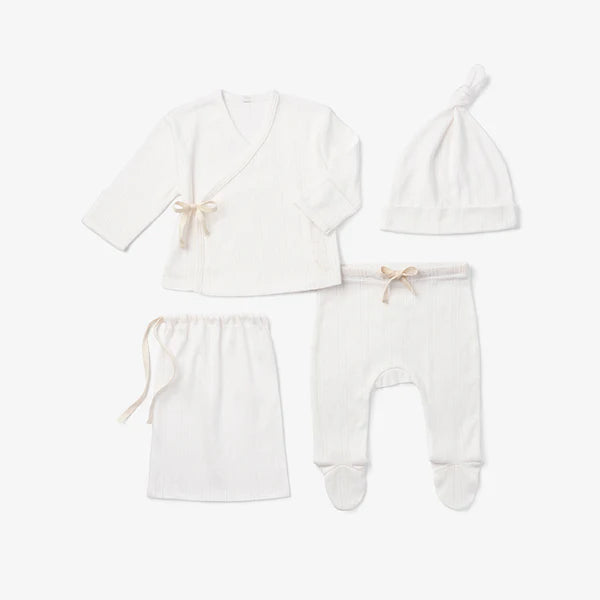 Four-piece white cotton knit newborn take-me-home set displayed together on white background